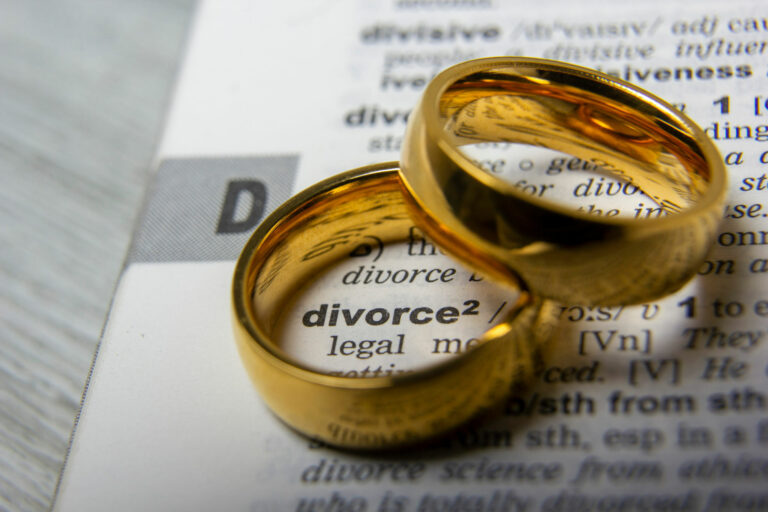 two golden wedding rings on divorce papers