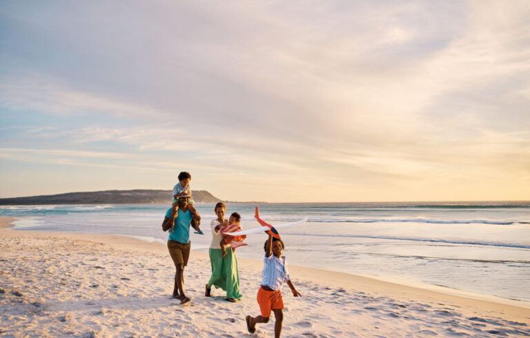 young couple walking on the beach with children in kenya