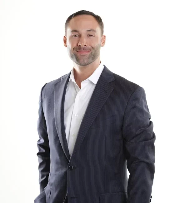 expat business man in a suit smiling at a camera